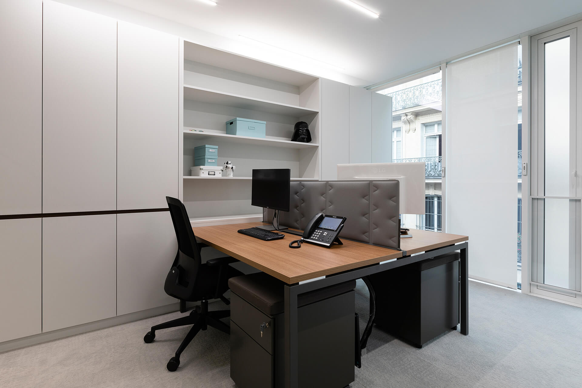 escritório com estantes brancas e mesa em madeira